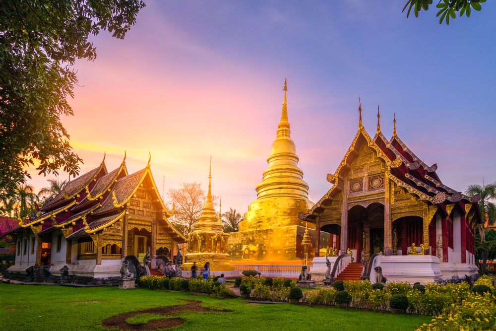 A panoramic view of the temple grounds at Wat Phra Singh, showing the golden spires and intricate details of the buildings.